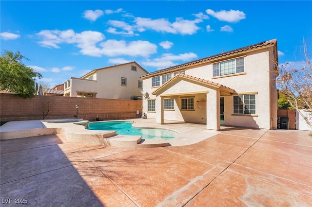 back of property featuring a patio, a fenced backyard, a tiled roof, a pool with connected hot tub, and stucco siding