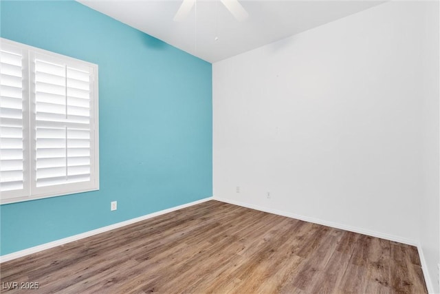 empty room with ceiling fan, baseboards, and wood finished floors