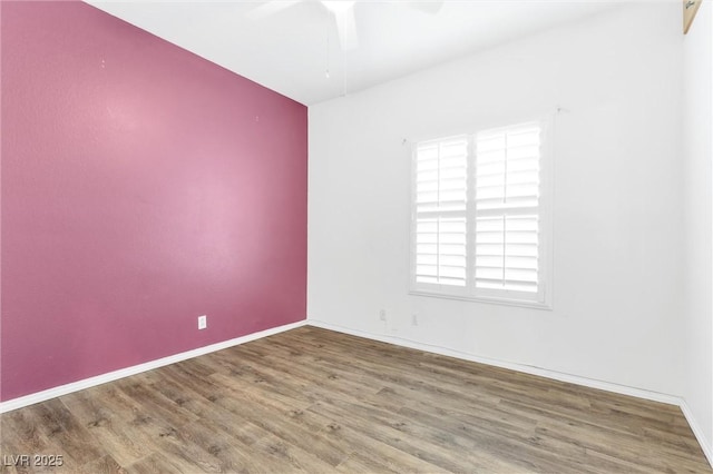 spare room with a ceiling fan, baseboards, and wood finished floors