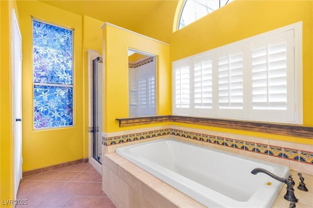 full bath featuring tile patterned flooring, a shower stall, and a bath