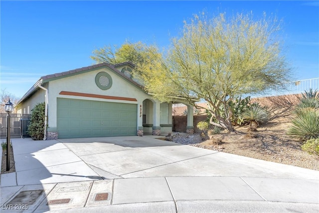 view of front of property featuring concrete driveway, fence, an attached garage, and stucco siding