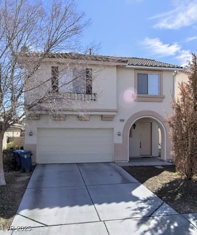 traditional home featuring concrete driveway, a tiled roof, and stucco siding