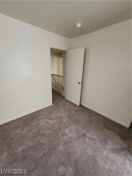 carpeted empty room featuring baseboards