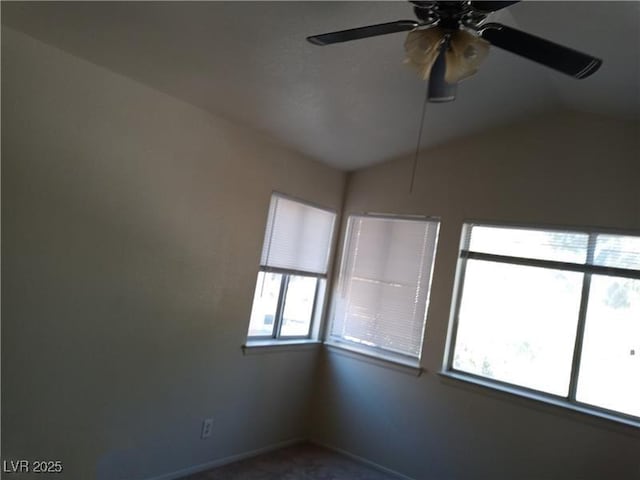 empty room featuring ceiling fan, baseboards, and vaulted ceiling