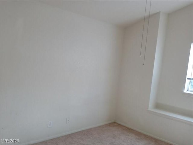 unfurnished room with baseboards and light colored carpet