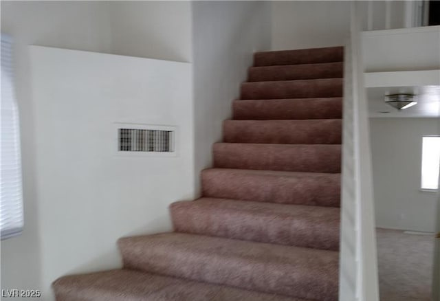 staircase with carpet floors and visible vents