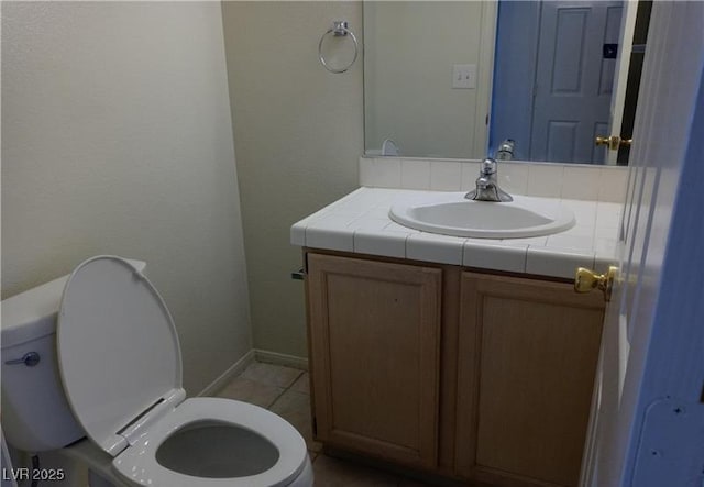 bathroom featuring toilet, tile patterned floors, and vanity