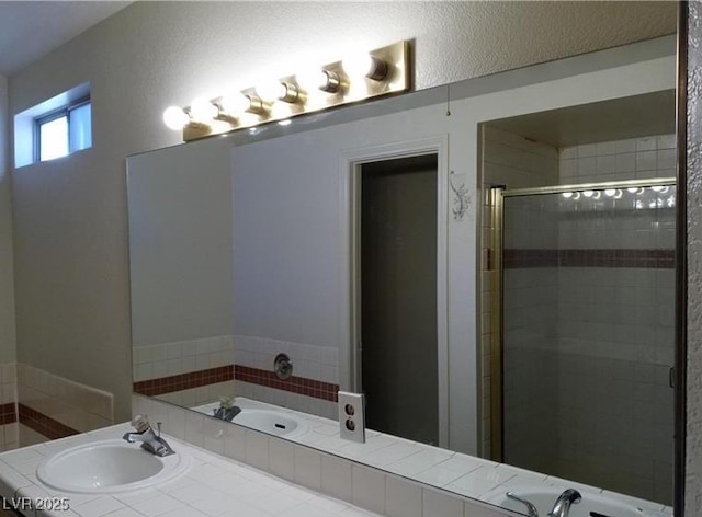 bathroom featuring a stall shower and a sink