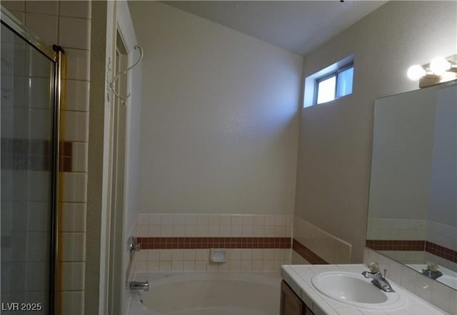 full bathroom with vanity, a bath, and a shower stall