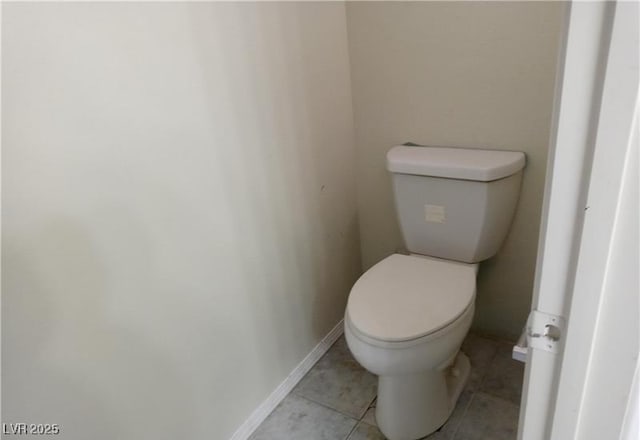 bathroom featuring baseboards, toilet, and tile patterned floors