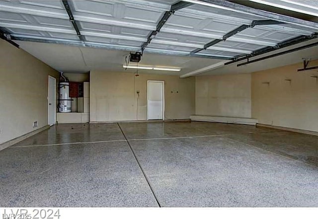 garage featuring strapped water heater and a garage door opener