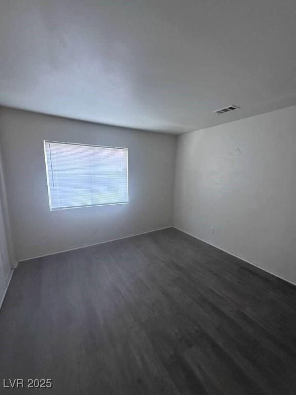 spare room with dark wood finished floors and visible vents