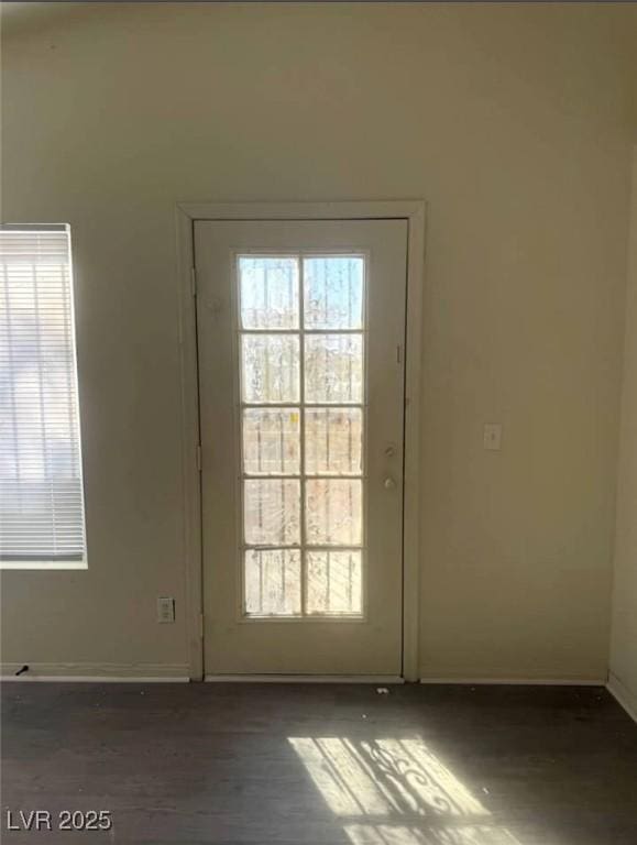 doorway with baseboards and wood finished floors