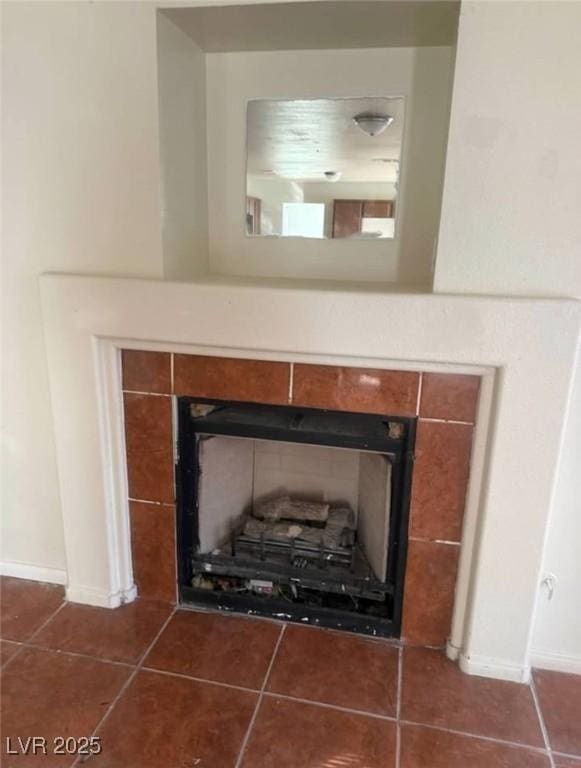 details featuring baseboards and a tile fireplace