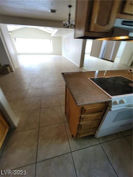 kitchen with light tile patterned floors, white electric stove, and brown cabinetry