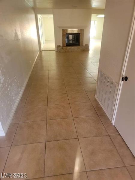 hallway with light tile patterned flooring and baseboards