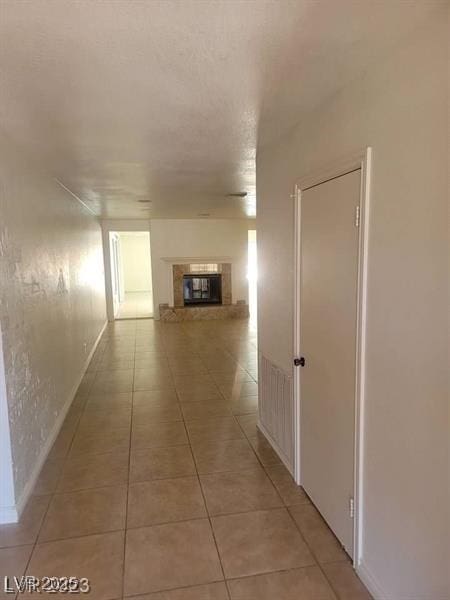 hallway featuring light tile patterned floors and baseboards