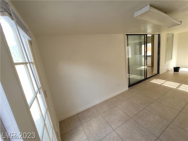 spare room with light tile patterned floors and baseboards