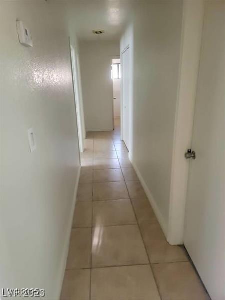 hall with light tile patterned floors and baseboards