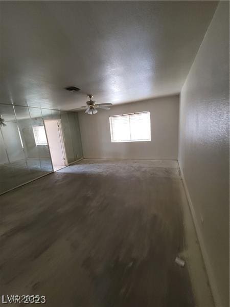 spare room featuring light wood finished floors, baseboards, and a ceiling fan