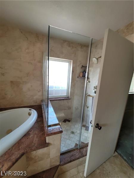 bathroom with a washtub and a stall shower