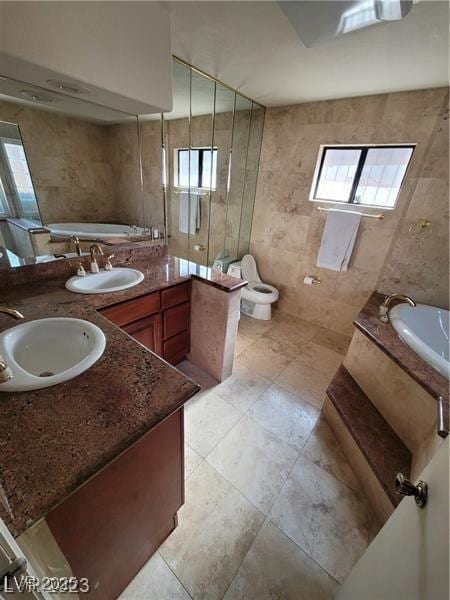 full bath with double vanity, a garden tub, and a sink