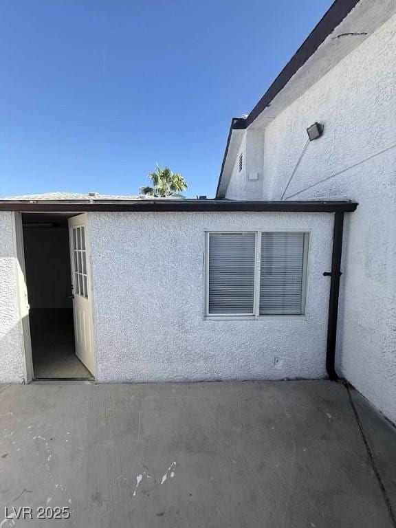 view of side of home featuring a patio area and stucco siding