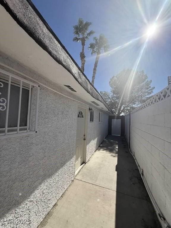 view of property exterior featuring fence, a patio, and stucco siding