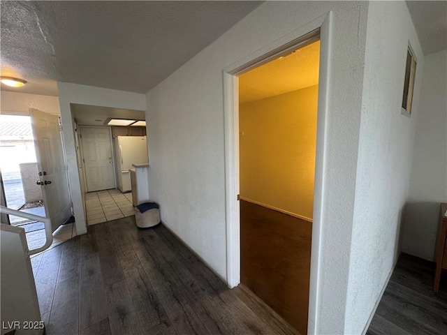 hallway with hardwood / wood-style flooring and a textured ceiling