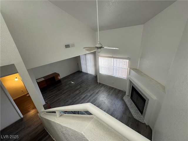 living area featuring a ceiling fan, a brick fireplace, visible vents, and wood finished floors