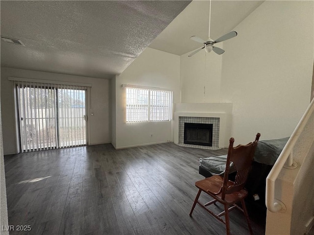 unfurnished living room with a fireplace, wood-type flooring, visible vents, and a healthy amount of sunlight