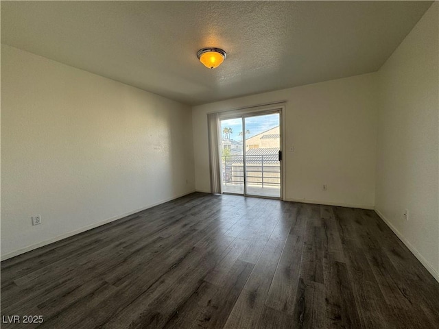 unfurnished room with dark wood-style floors, a textured ceiling, and baseboards