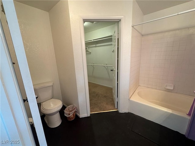 full bathroom featuring a spacious closet, shower / washtub combination, toilet, and baseboards