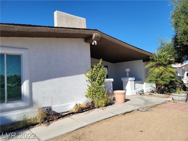 view of side of home with stucco siding