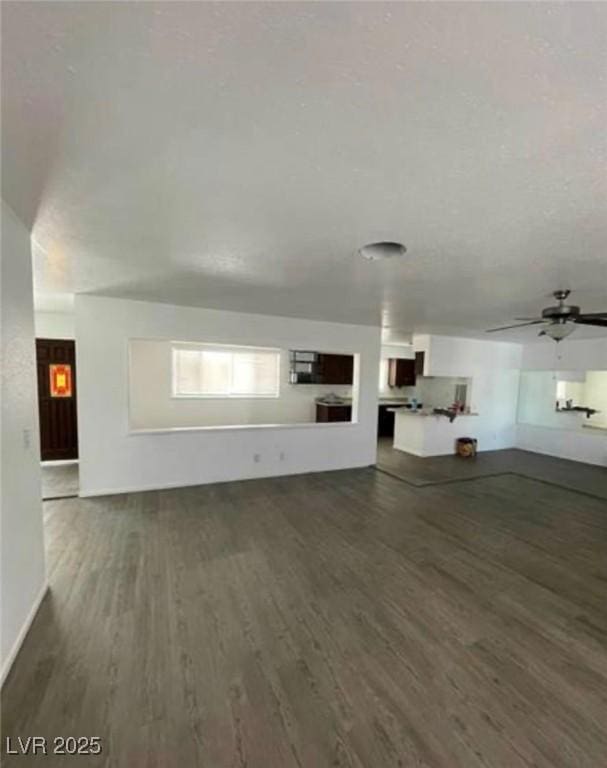 unfurnished living room with ceiling fan and wood finished floors