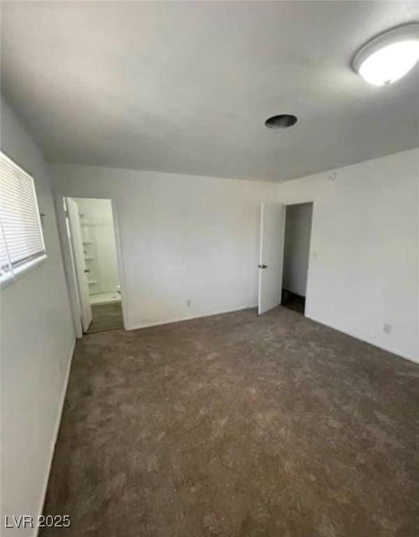 unfurnished bedroom featuring ensuite bath and carpet