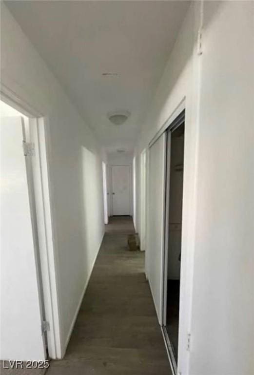 hall with dark wood-style flooring and baseboards