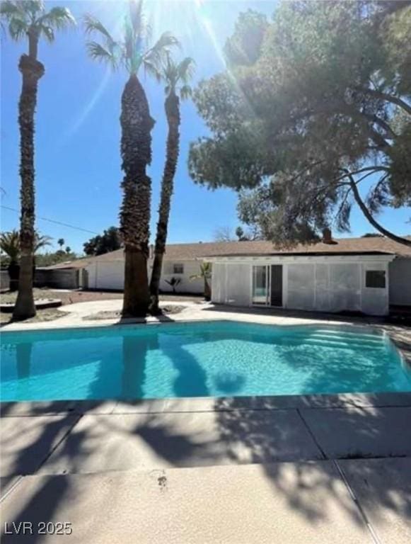 outdoor pool with a patio area and fence