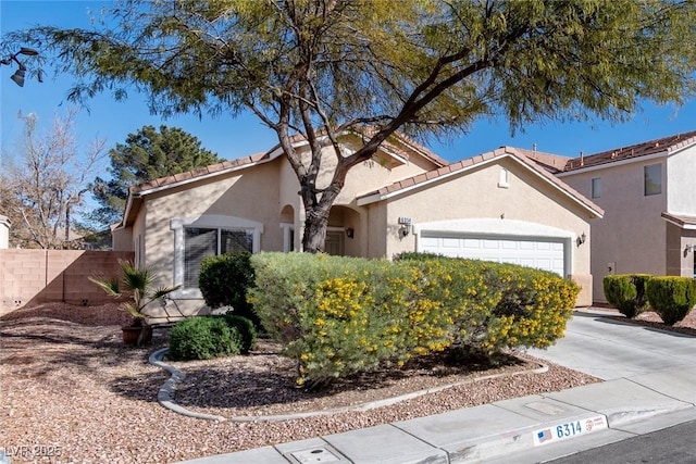6314 Ruby Cedar Ct, North Las Vegas, NV 89031 - mediterranean / spanish home featuring fence, an attached garage, stucco siding, concrete driveway, and a tile roof