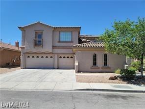 view of front of home featuring a garage, driveway, a tiled roof, and stucco siding