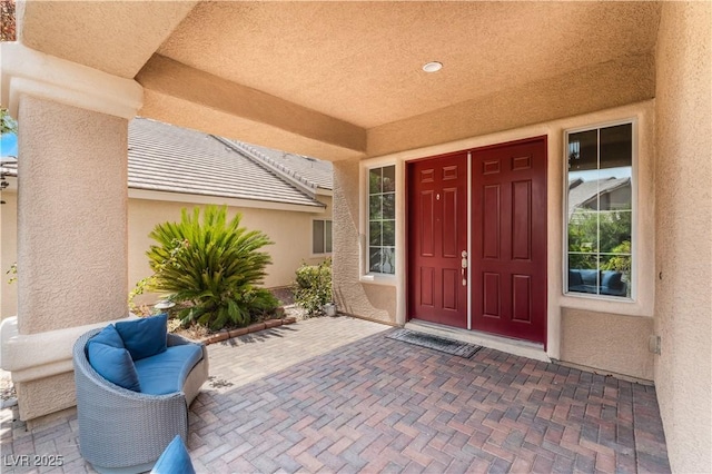 property entrance with a patio area and stucco siding