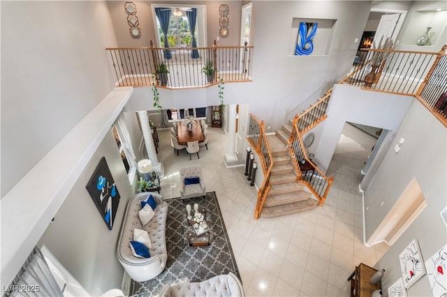 living room with stairs, a high ceiling, and tile patterned floors