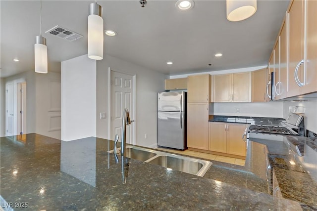 kitchen with light brown cabinets, visible vents, stainless steel appliances, and a sink