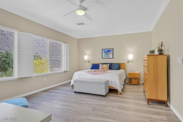 bedroom with visible vents, crown molding, light wood-style flooring, and baseboards