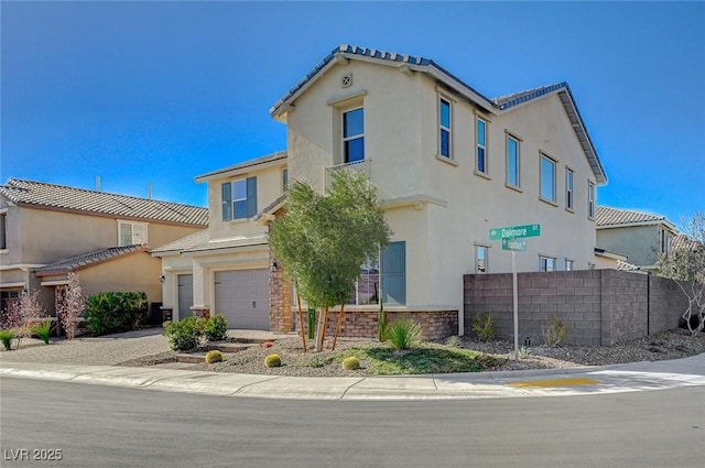 view of front facade featuring driveway, an attached garage, fence, and stucco siding