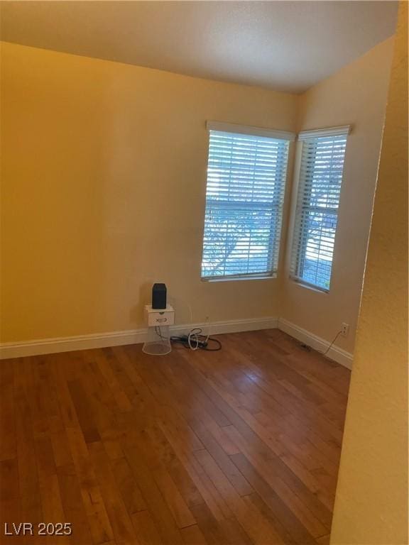 unfurnished room with wood-type flooring and baseboards