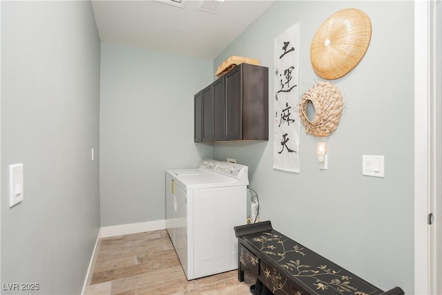 laundry room with light wood-style flooring, visible vents, baseboards, washer and dryer, and cabinet space