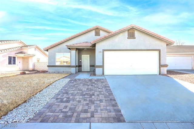 view of front of home featuring a garage, driveway, and stucco siding