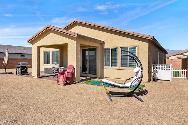 back of property with fence, a patio, and stucco siding