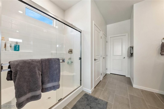 full bathroom featuring tile patterned flooring, a shower stall, and baseboards